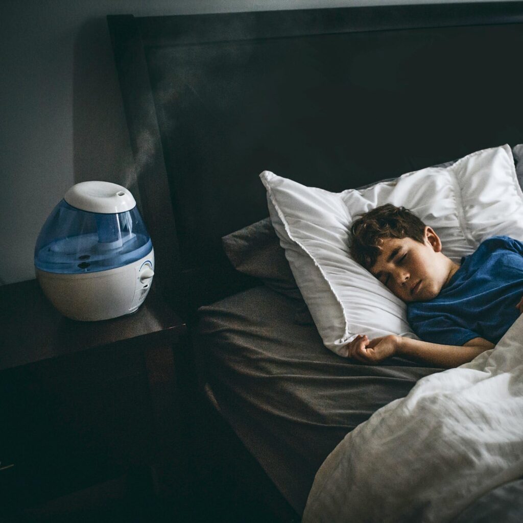 niño durmiendo con humidificador vicks vul520 puesto